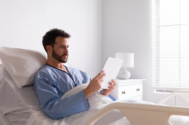 person using a tablet during bed rest